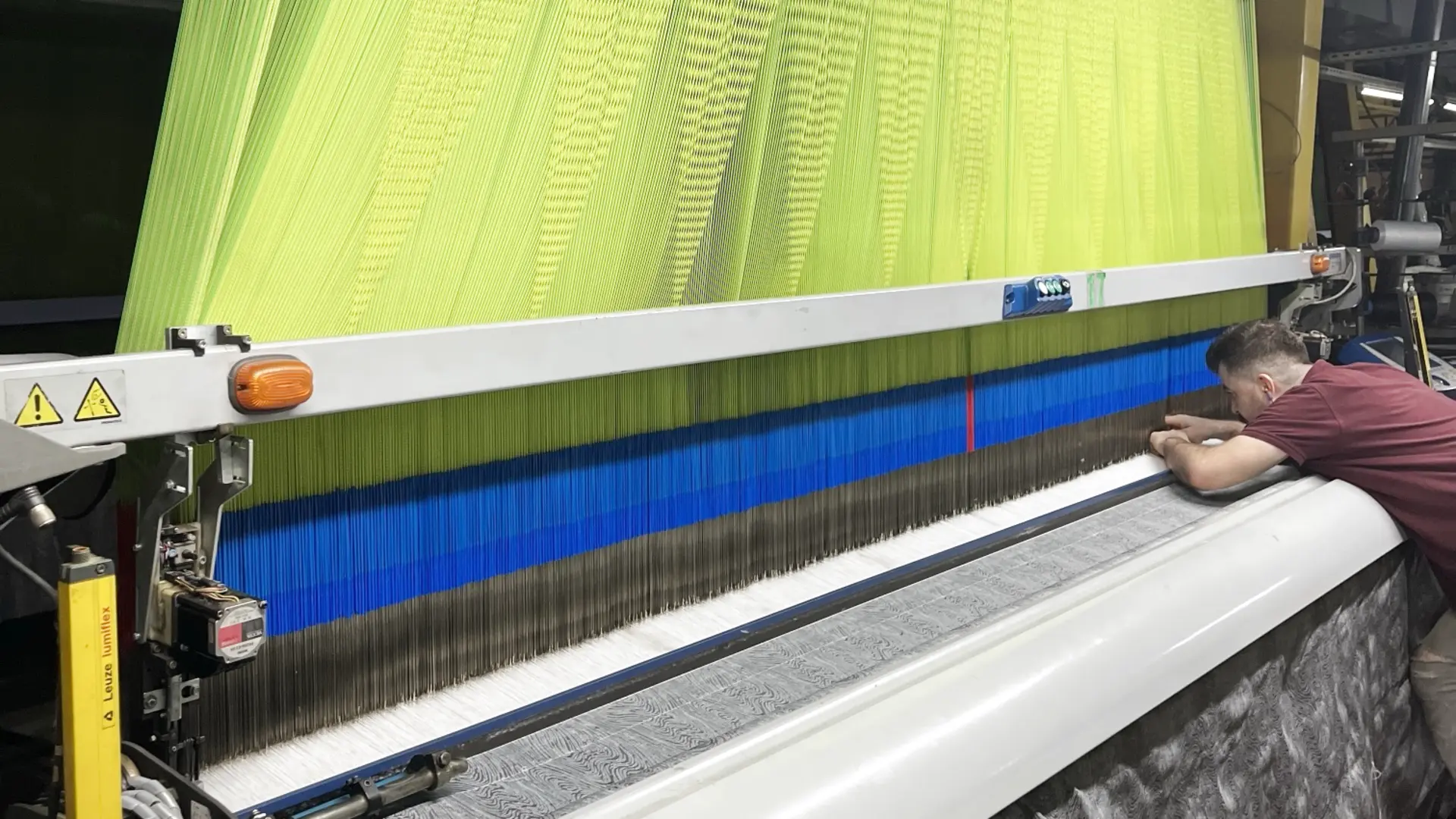Our weaver checking patterned fabric on a jacquard loom