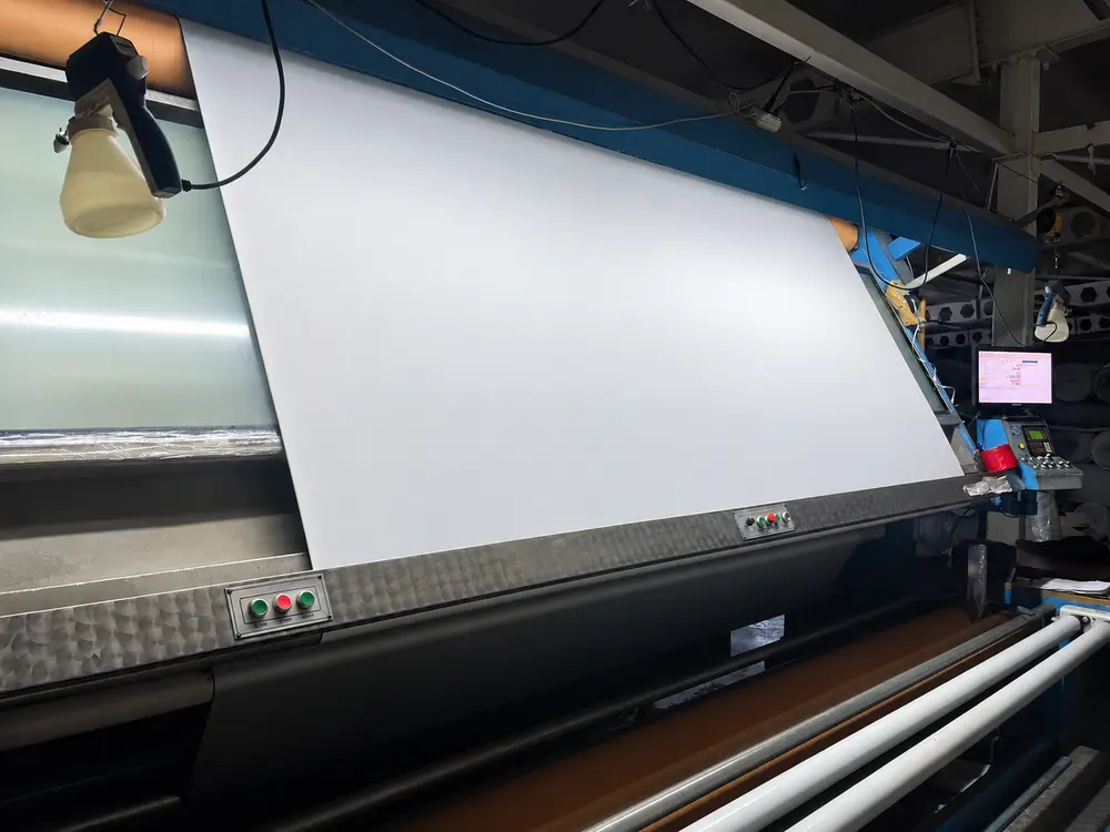 White fabric inspected under light on a fabric inspection machine