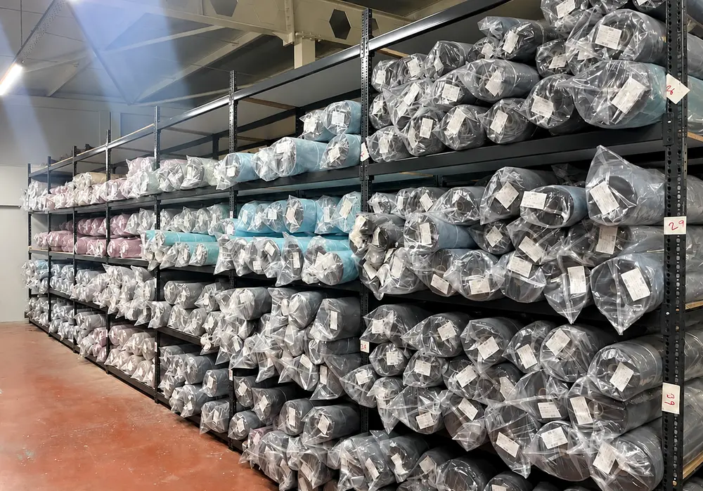 Labelled, bagged fabric rolls stacked on the shelves of our warehouse
